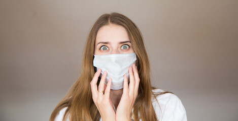 Portrait of a girl who covered her face with a mask. Frightened eyes of the patient.