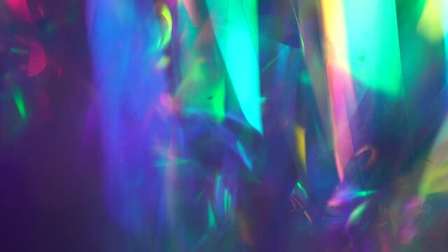 Crystal prism refracting light in vivid rainbow colors. Diamond neon purple holographic background