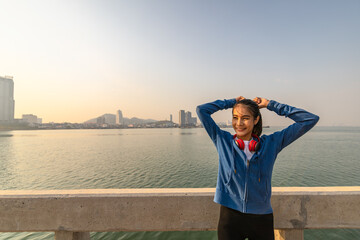 Young sport woman tying hair before her running and city background in the morning.