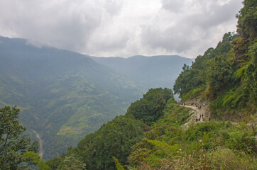 Fototapeta na wymiar Tourists follow the trail among the mountains of Nepal Himalayas 