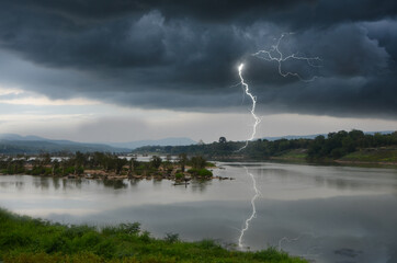 Strong lightning and black clouds over the river