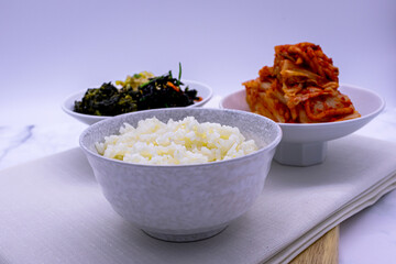 Korean food with rice, kimchi, side dishes.