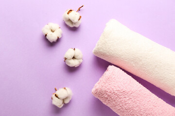 Obraz na płótnie Canvas Cotton flowers and soft towels on color background