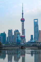 Fototapeta premium Zachód słońca widok na most Waibaidu i Lujiazui, panoramę i punkt orientacyjny w Szanghaju w Chinach, z odbiciem z przodu.
