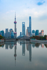 Obraz premium Sunset view of Waibaidu Bridge and Lujiazui, the skyline and landmark in Shanghai, China, with reflection in front.