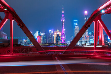 Fototapeta na wymiar night view of Waibaidu Bridge, a historic landmark in Shanghai, with traffic inside and skyscrapers in then back.