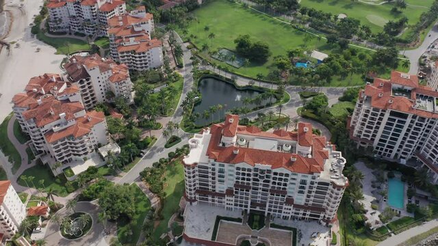 4K aerial view of the prestige residential homes and apartments on the Fisher Island, in Miami suburban area, Florida state. Exclusive real estate with the ocean view. Front line buildings with pools