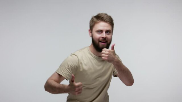 Well done, like it! Satisfied extremely happy bearded guy looking at camera cheerful joyful, doing thumbs up, laughing dancing carefree with approval agreement finger up gesture. studio shot isolated