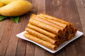 Thai dessert Mango sheet ,Sun dried mango paste roll on white plate.