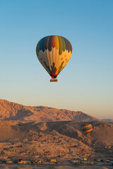 Fototapeta na wymiar Hot air Balloons over Valley of the King in Luxor city in a morning sunrise, Upper Egypt