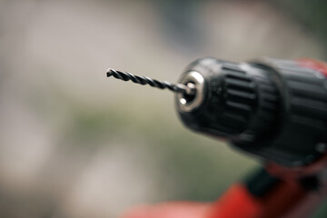 close up of drill bit on drill instrument. professional tool. woodwork static. screwdriver outdoor on blurred background