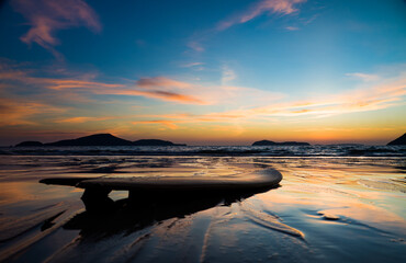 Naklejka premium Surfboard on the beach at sunset