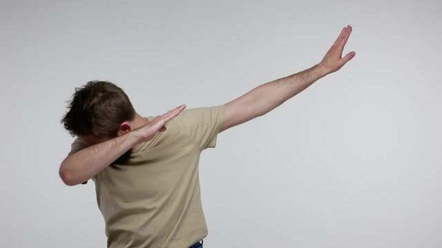 Carefree optimistic bearded guy dancing laughing and showing dab dance pose, expressing joy happiness, success celebration with internet meme triumph gesture, dabbing trends. studio shot isolated