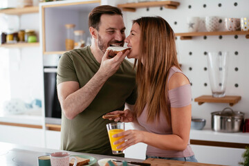 Young couple eating breakfast at home. Loving couple enjoying in the morning.