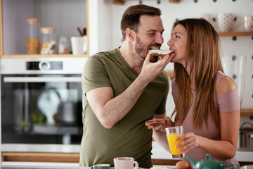 Young couple eating breakfast at home. Loving couple enjoying in the morning.