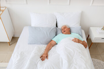 Obraz na płótnie Canvas Mature man snoring while sleeping in bed. Apnea problem