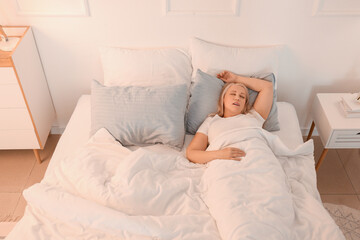 Fototapeta na wymiar Mature woman snoring while sleeping in bed. Apnea problem