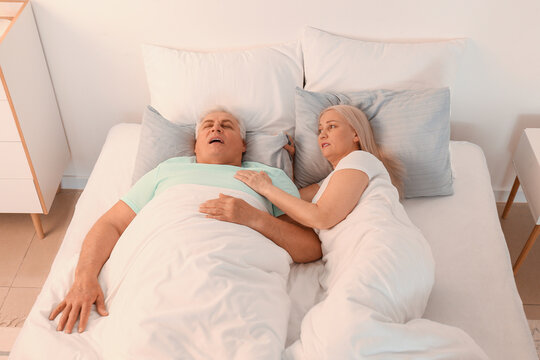 Mature Irritated Woman In Bed With Snoring Husband
