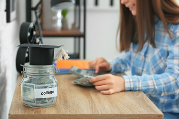 Teenage girl with savings for education and calculator at home