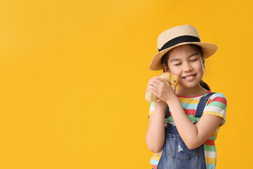 Little girl with cute duckling on color background