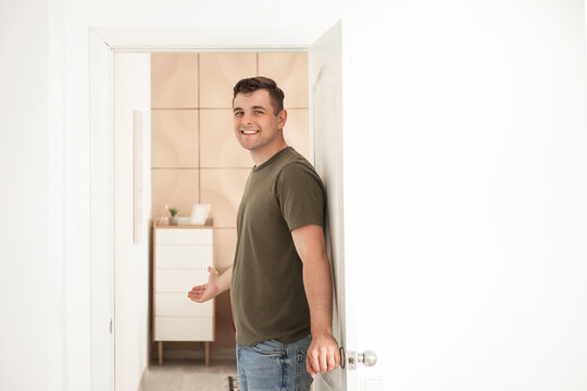 Happy man inviting guest at his new home