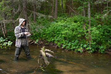 angler with a spinning rod on a little northern river