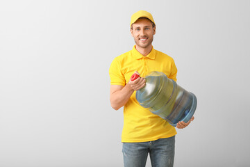 Delivery man with bottle of water on grey background