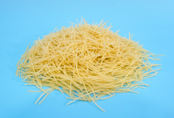 small uncooked pasta isolated on blue background.
