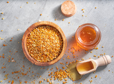 Top view of honey and pollen over gray background