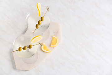 Glasses of tasty martini cocktail with olives on light background
