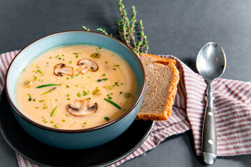 Delicious mushroom cream soup with champignons on the gray table