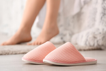 Pair of soft slippers on floor in bedroom