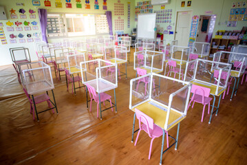 Fototapeta New normalno classrooms The Social distancing in classrooms and kindergartens that are about to be opened during the coronary epidemic, or Covid-19, have plastic sheets between students. obraz