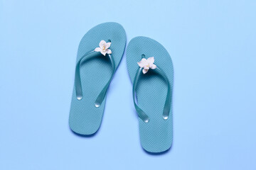 Stylish flip-flops on color background