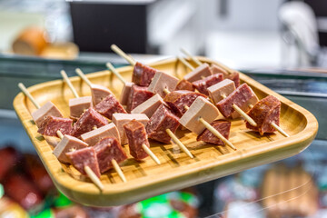 Thin slices of meat, ham, bacon lie on a white plate.