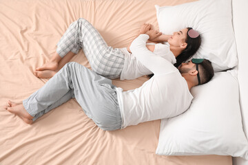Young couple sleeping in bed, top view