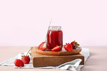 Jar of tasty strawberry jam on table