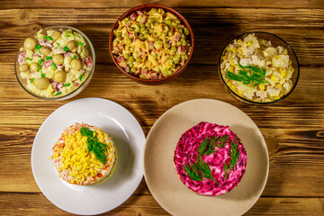 Set of festive mayonnaise salads on wooden table. Top view