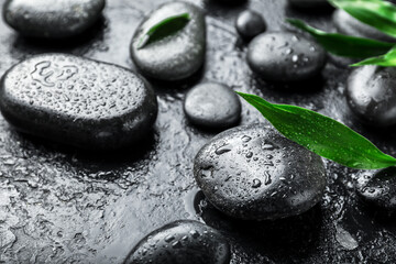 Spa stones and bamboo leaves on dark background