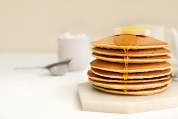 Tasty pancakes with butter and honey on table