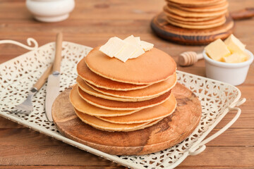 Tasty pancakes with butter on table