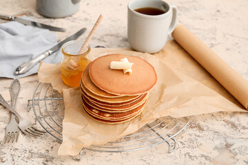 Tasty pancakes with butter, honey and coffee on table