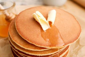Tasty pancakes with butter on table, closeup