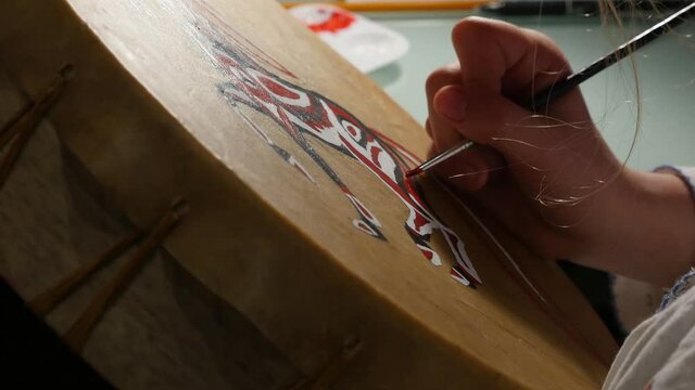 Girl painting a drum.