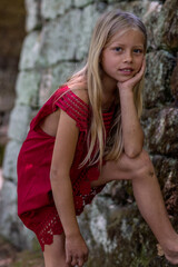 Porträt eines jungen, hübschen, manchmal nachdenklich oder frechen Mädchens in einem schicken roten Kleid.