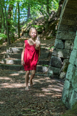 Porträt eines jungen, hübschen, manchmal nachdenklich oder frechen Mädchens in einem schicken roten Kleid.