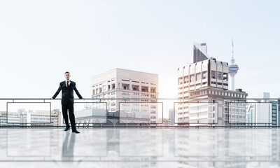 Sunrise above skyscrapers and businessman facing new day