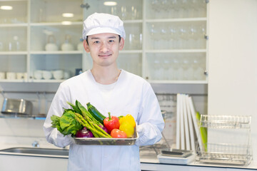 野菜を持つ男性調理師