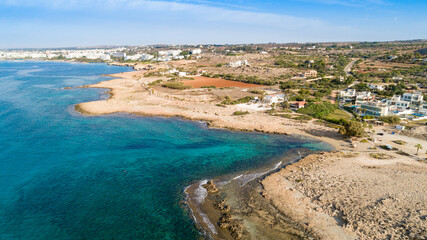 Aerial bird's eye view of Ammos tou Kambouri beach, Ayia Napa, Cavo Greco, Famagusta, Cyprus. Tourist attraction bay, rocky beach with golden sand, sunbeds, sea restaurant in Agia Napa from above.