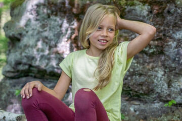 Obraz premium Mädchen beim unbeschwerten Sport und turnerischer Bewegen, wie Akrobatik in der Freizeit, im Wald und in der Natur. Sie trägt legere Kleidung, Shirt und Leggins.